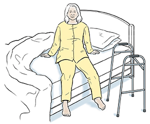 Woman preparing to lie down in bed. Walker by bed.