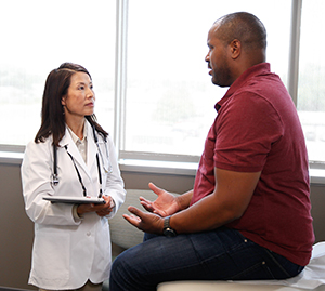 Man in exam room talking to doctor.